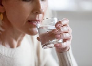 femme boit un verre d'eau